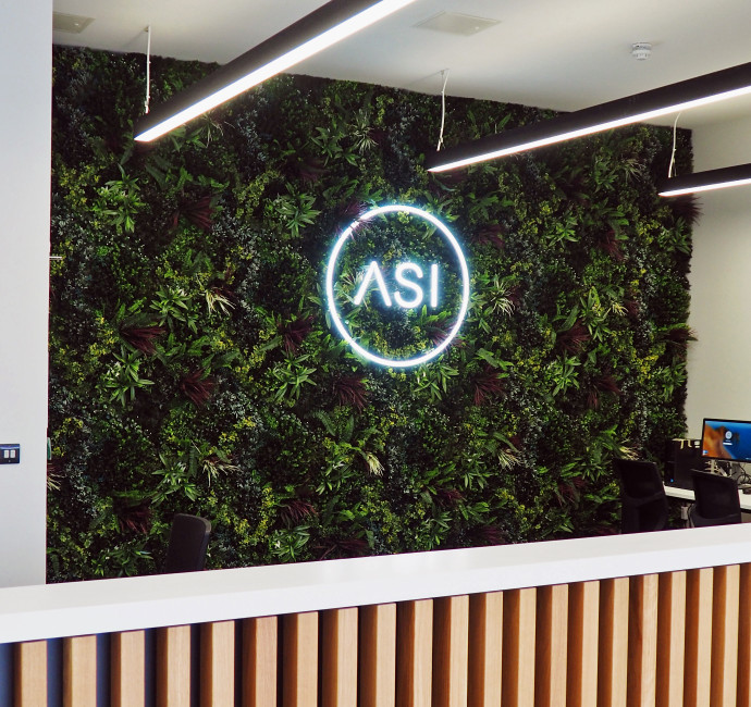 ASI neon lettering on a green wall signage design