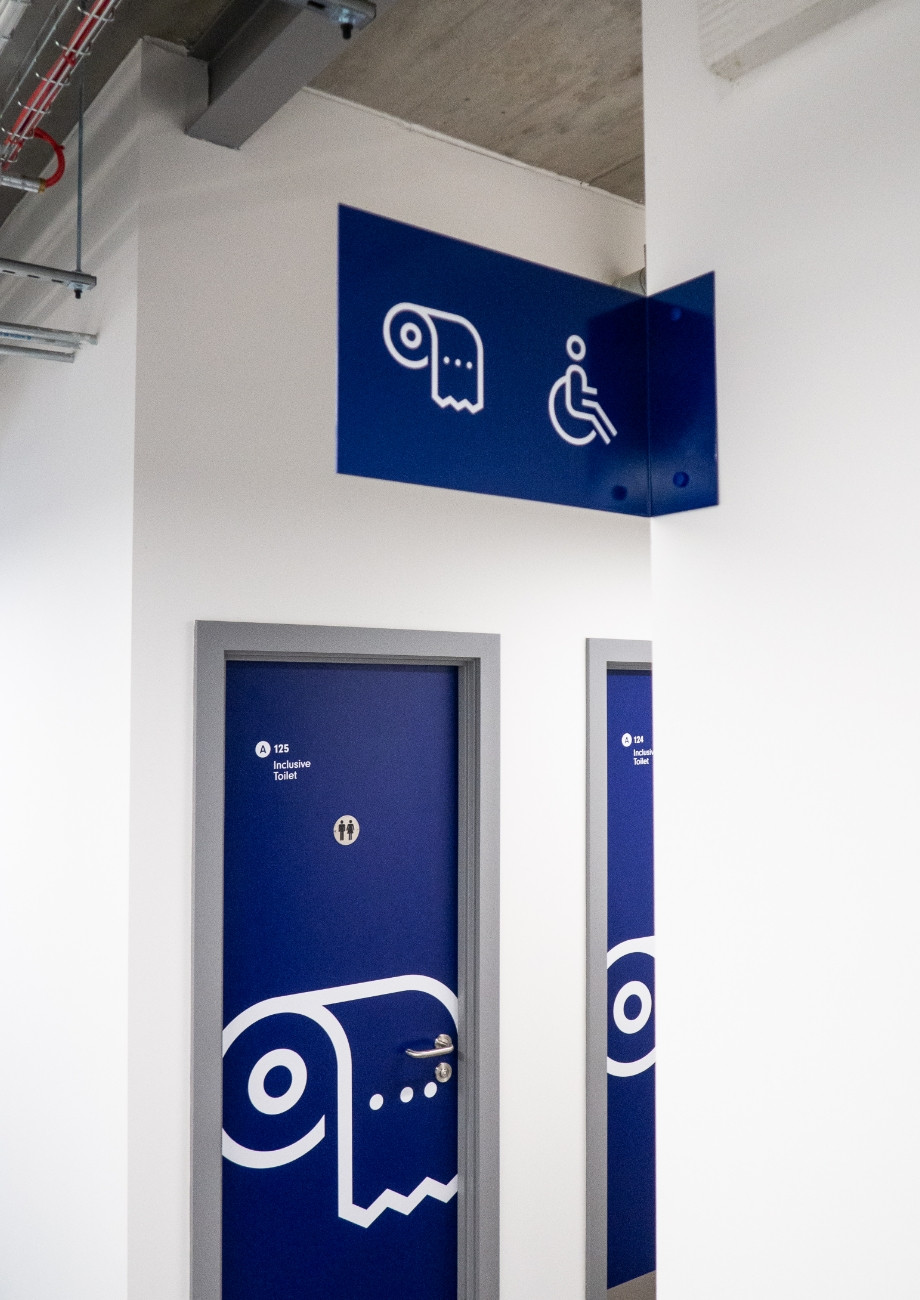 ASI college wayfinding overhead toilet shower icon sign door graphic design