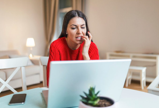 Woman using a laptop biting her nails