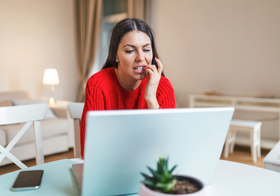 Woman using a laptop biting her nails